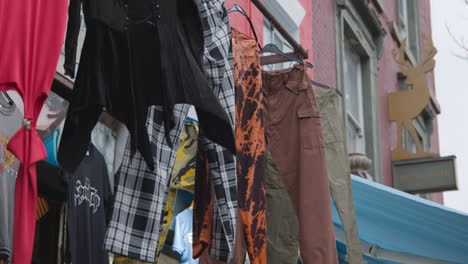 Close-Up-Of-Clothes-Hanging-Outside-Shops-On-Camden-High-Street-In-North-London-UK